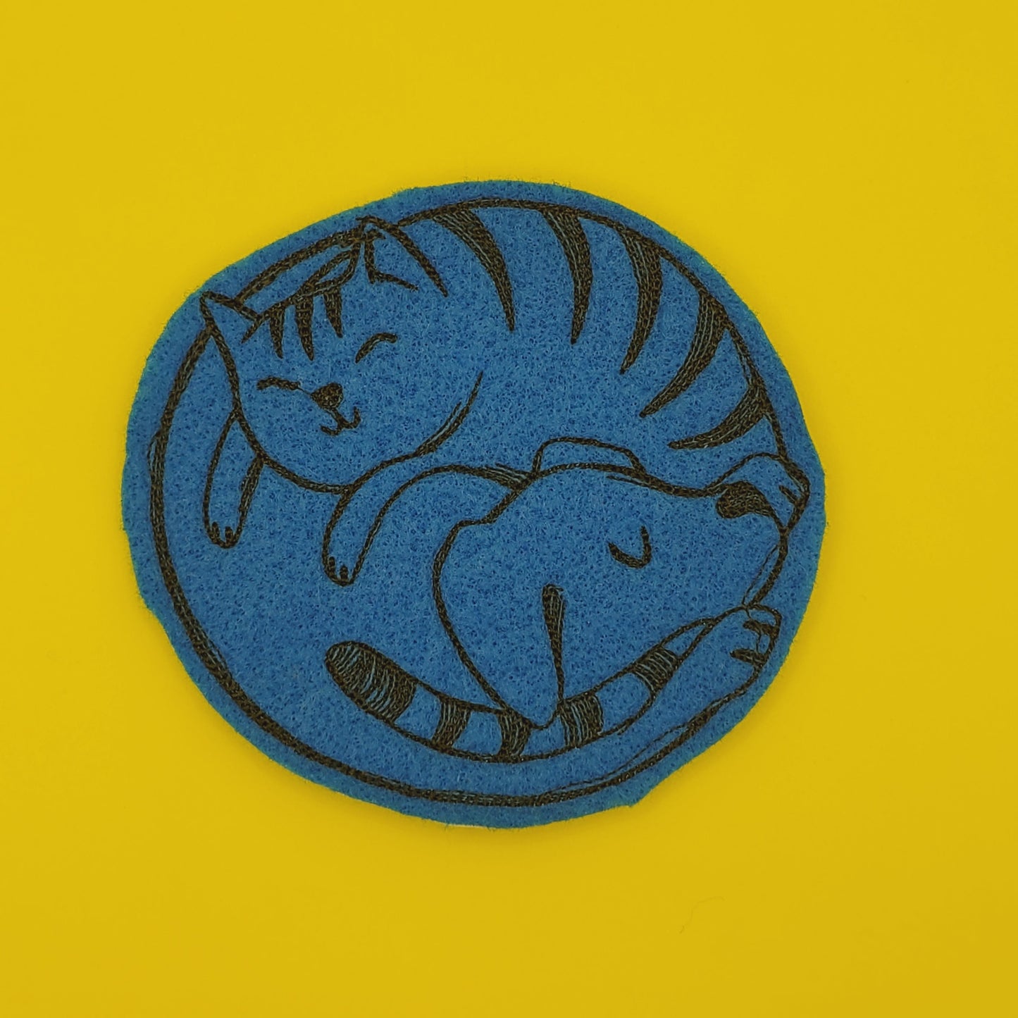 Cat and Dog Coaster stitched in black on blue felt